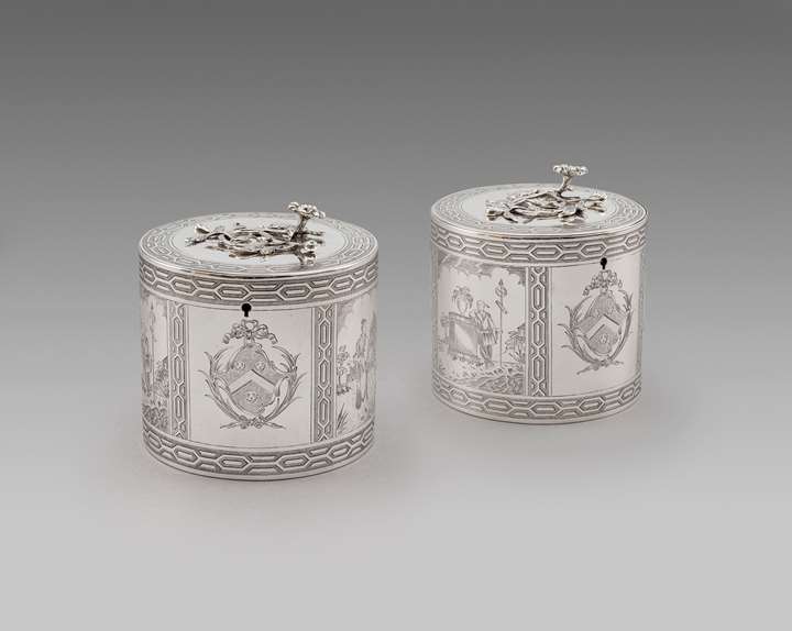Pair of George III silver circular tea caddies engraved with Chinoiserie scenes in a fitted wooden container